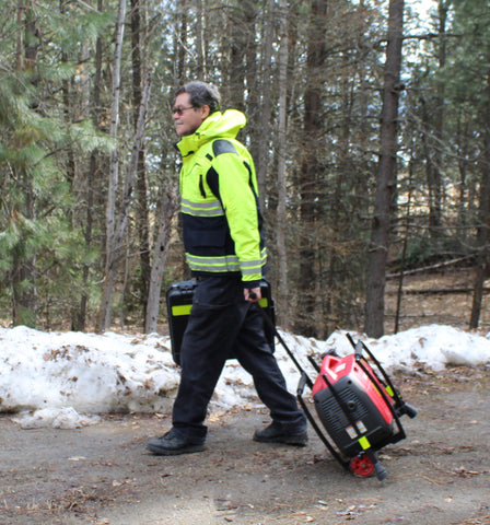 James is shown transporting Lentry Lighting System Model 2SPECS-C23 with the Wheels & Handle Kit on compact dirt. The V-Spec LED and standard height pole are stored inside the case.