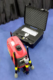 Taken at a tradeshow, this picture shows portable Lentry system model 1SPECS-C23 with the 1000 watt generator and fully retracted all-terrain legs and telescoping pole to the left, while the V-Spec LED light head is stored inside the opened Case C2318 to the right.