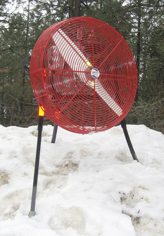 A base model 24-inch VENTRY Fan Model 24GX120 is shown standing in a large and uneven snow pile. The three independently adjustable legs  allow the fan to stand solid and be placed where needed and not just on flat surfaces..