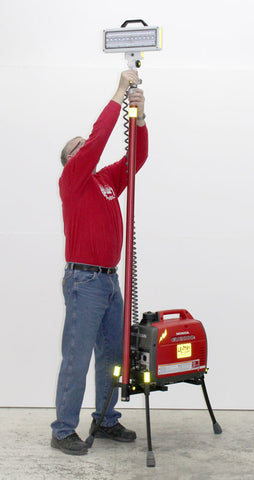 Hi-Lite Lentry Lighting System Model 2SPECH with the all-terrain legs extended and the telescoping LED retracted, standing next to a 6 feet tall man.